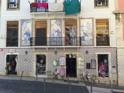 a building with a tableau of painted tiles on second floor