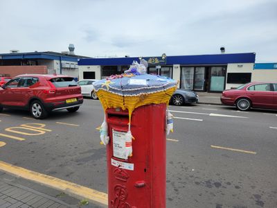 Pillar mailbox with a knitted cozy on top