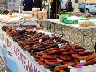 a table loaded down with cured sausages.