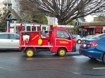 A japanese delivery truck painted red and labeled like a Tonka toy