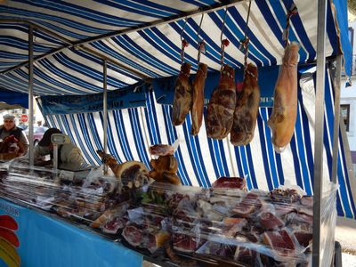 a row of hanging cured ham legs