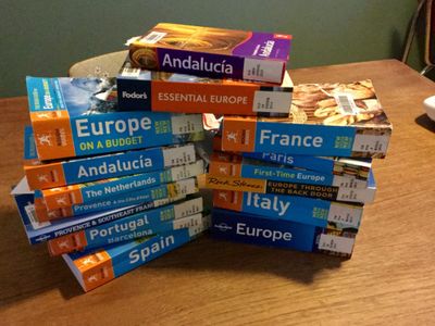 a large stack of travel guidebooks