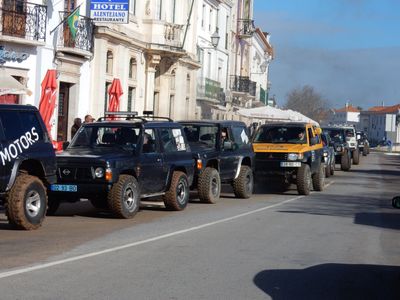 a long row of off-road trucks parading up the street.
